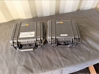 Two Pelican cases closed, top view with labels and handles visible
