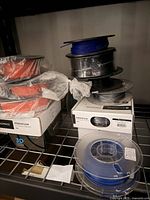 Multiple filament spools and Monoprice boxes on shelf