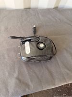 top view of black aquarium air pump showing power cord and outlets