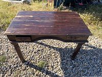 Full view of antique wooden desk on gravel