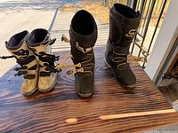 Both pairs of boots side by side on table