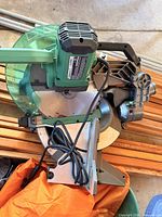 Full view of Metabo HPT compound miter saw showing blade guard, base and cord