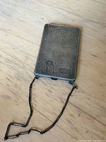 Front view closed showing textured sterling exterior and chain