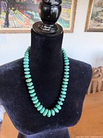 Front view of graduated turquoise bead necklace on display bust