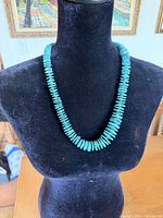 Full view of turquoise disc necklace on display bust