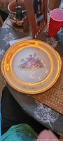 large handled platter showing gold rim and central courting scene