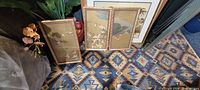 Three Asian art panels on patterned rug showing size, frames and motifs