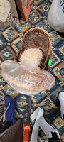 Oval basket with shredded paper and round tray wrapped in plastic