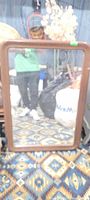 Full view of the brown-framed rectangular mirror