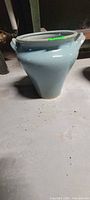 Front view of large blue glazed ceramic pot on floor