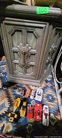 cabinet front view with door closed and toy cars lined in front