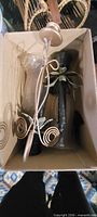 Box containing gold-tone wall sconce, two black metal candle holders and glass sleeves