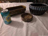 Group shot of two planters and ashtray with can for scale
