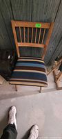 Front view of wood chair showing slat back and striped upholstered seat