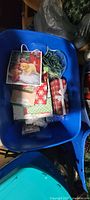 Blue tote containing gift bags, plaid gift box, string lights