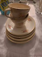 Stack of five floral porcelain saucers with two matching cups on top