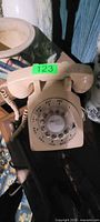 Top view of cream rotary dial telephone with handset and cord