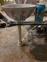 Side view of bowl next to soda can for scale
