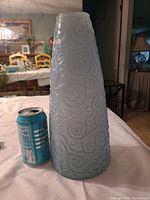 Full view of pale blue frosted glass vase beside soda can for scale