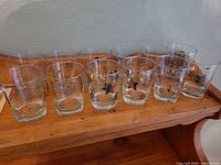 Full set of 12 leaf-decorated tumblers on wooden surface