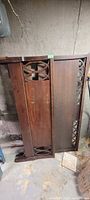 Mahogany headboard and footboard standing vertically showing panels and decorative cut-outs