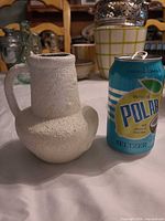 Jug beside soda can showing size, texture, handle and shape