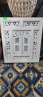 Front view shutters closed showing carved panels