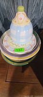Stack showing lidded bowl atop pastel and solid plates