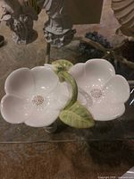 Top view of white double-flower ceramic serving dish showing green handle