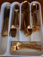 Full view of gold plated flatware set in tray