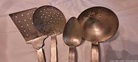 Close-up of utensil heads highlighting shapes and wear