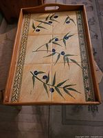 Full view of rectangular wooden tray showing tiled base and handles