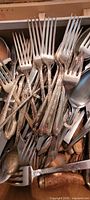 Close-up of mixed forks, spoons, knives showing quantity and condition
