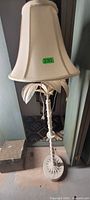 Full view of white palm motif floor lamp with shade