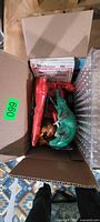 Open box showing View-Master packets, red squirt gun, green alligator squirter, action figure and clear compartment case