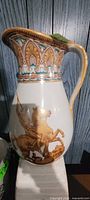Front view of ceramic vase showing figural horsemen scene and decorative rim