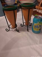 Both terracotta bud vases in their metal stands shown side by side for full view and scale reference