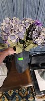 Purple faux hydrangeas in dark rectangular vase, close view