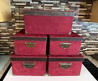 Front view showing five burgundy storage boxes stacked, hardware and trim visible