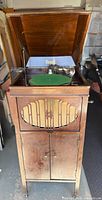 Full view of open Brunswick phonograph cabinet showing turntable, tonearm and lower record doors