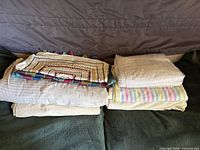 Stacked linens showing mats, duvet covers, bed cover