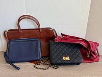 Group shot of all four purses standing on table