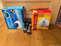 Boxed Vicks and Sunbeam humidifiers with pair of chrome dumbbells