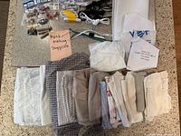 Entire lot laid out: fabric pieces, packaged notions, thread, beads, elastic, pipe cleaners