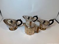 Group shot of four silver-plated teapots showing overall styles and quantity
