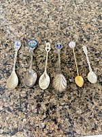 All six souvenir spoons laid out