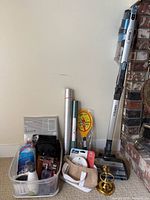 Group shot of vacuum standing with household items tote, insulation rolls, faucet covers, brass sconce