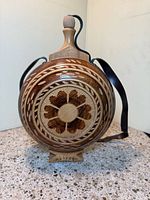Front view showing carving, stopper, stand, strap