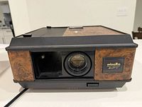 Front view of Minolta Autopak AFT projector showing lens and wood-grain panel