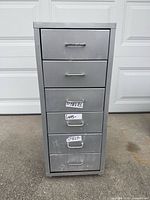 Front view showing five drawers with metal handles and labels